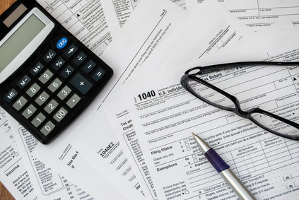 pen, glasses and calculator on a tax form in Dallas, TX