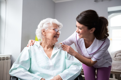 Older woman smiling with nurse at home in Dallas, TX