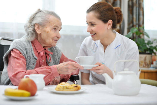 Home care provider having coffee with an older woman in Dallas, TX